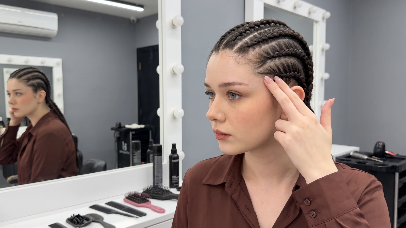 Woman checking her goddess braids at the hairline to test for tension and tightness